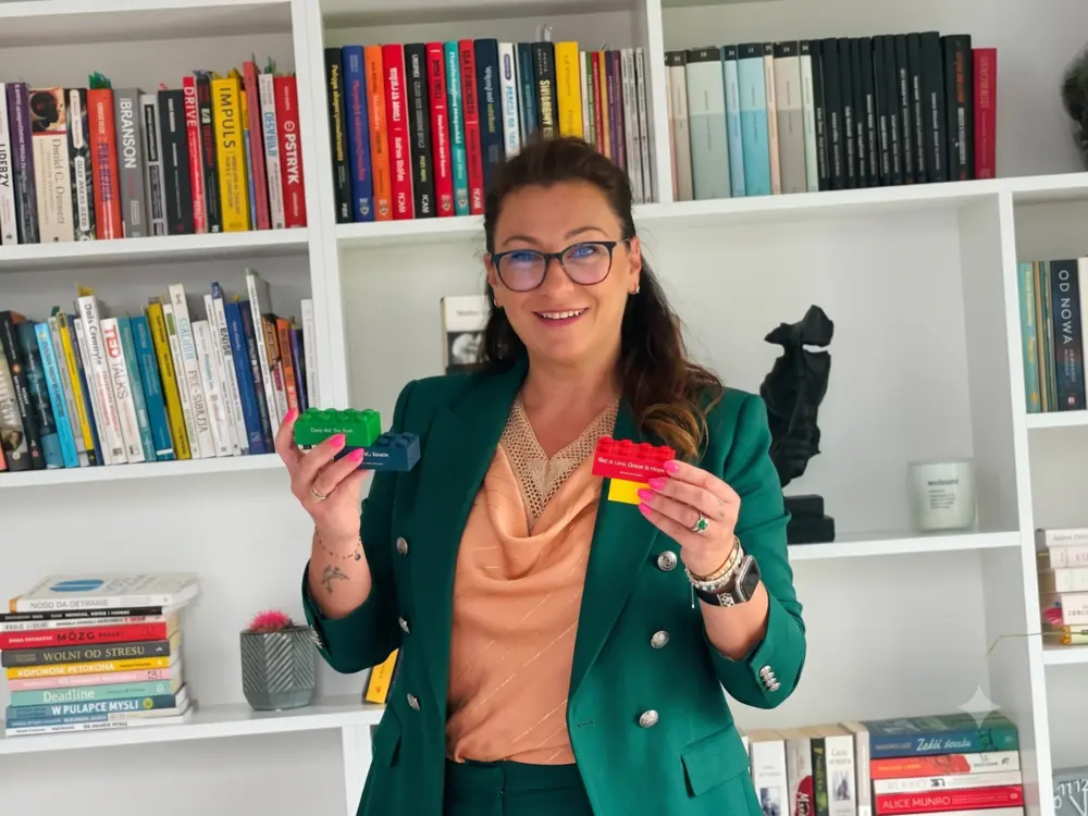 Aneta Gawlas w zielonej marynarce prezentuje karty kolorów osobowości